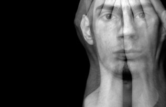 Et sort-/hvittbilde som viser en mann med hendene foran ansiktet. Hendene er transparente slik at man kan se ansiktet hans.