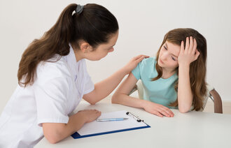 Bildet viser et helsepersonell som samtaler med en ung jente