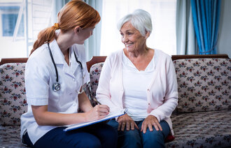 Lege i samtale med en eldre pasient