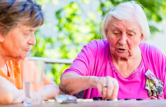 bildet viser to eldre damer som spiller brettspill
