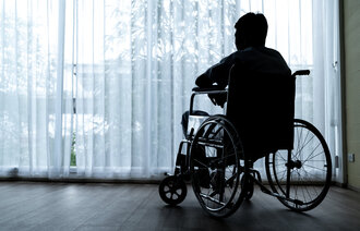 Bildet viser en mann som sitter i rullestol. 