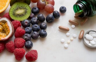 Bildet viser ulike frukter og bær samt kosttilskudd