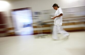 Bildet viser en sykepleier som går i en korridor.