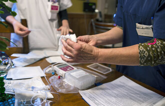 Bildet viser en sykepleier som gir en annen opplæring i bruk av epidural smertepumpe.