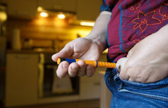 Bildet viser en person med diabetes som setter sprøyte