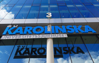 Bildet viser en bygning med et skilt der det står Karolinska i blå bokstaver.
