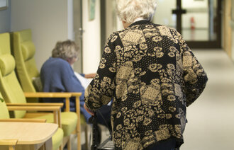 Eldre mennesker i sykehjemskorridor