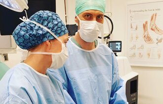 Bildet viser operasjonssykepleier som veileder en operasjonssykepleierstudent.