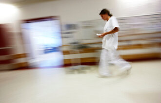 Bildet viser en sykepleier i en korridor.