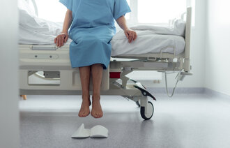 Bildet viser en eldre, oppegående kvinne på sykehus