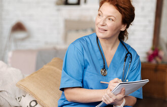 Bildet viser en sykepleier som skriver i en pasientjournal