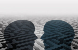 Bildet viser silhuetten av to mennesker som står ovenfor hverandre. I bakgrunnen kan man skimte en labyrint.