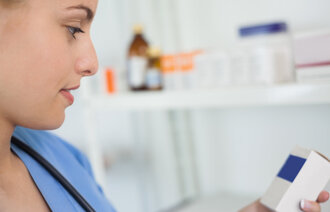 Bildet viser en sykepleier som studerer medikamenter