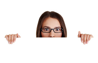 Bildet viser en kvinne med oppsperrede øyne som titter over en kant