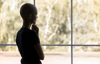 Bildet viser en kvinne med kreft som titter ut av vinduet.