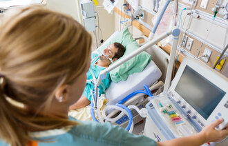 Sykepleier og pasient på intensivavdeling