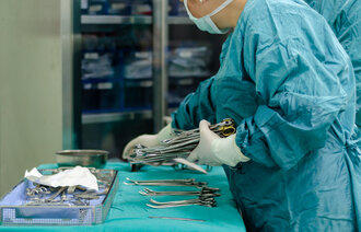 Bildet viser en sykepleier som dekker opp instrumentbordet før operasjon
