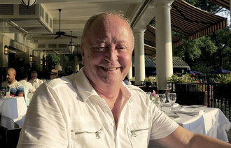 Bildet viser en smilende Jan Pedersen som koser seg på uterestaurant.