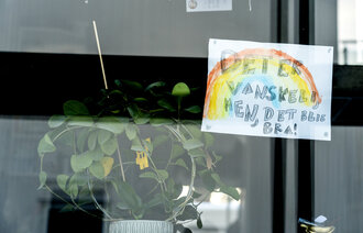 Bildet viser en vinduskarm hvor det henger et ark med en tegning av en regnbue og teksten "det er vanskelig, men det blir bra".