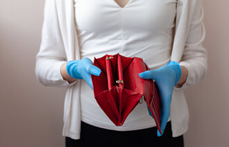 Bildet viser et utsnitt av en kvinne som viser frem en tom lommebok