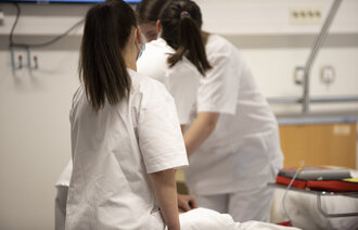 Bildet viser sykepleiere rundt en seng.