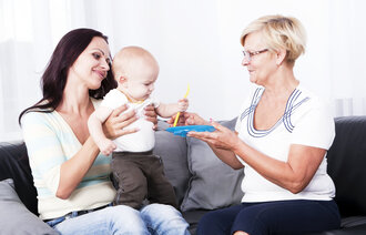 Bildet viser en helsesykepleier som er på hjemmebesøk hos en mor og baby