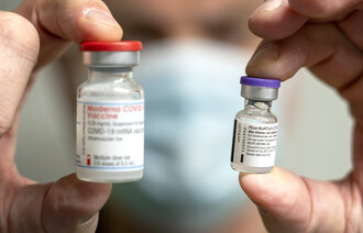 Bildet viser to hetteglass, ett med vaksine fra Pfizer/Biontech og et med vaksine fra Moderna.