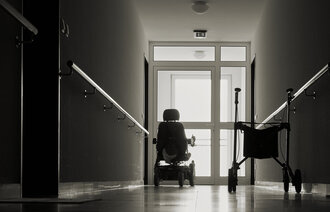 Rullator og rullestol i tom sykehjemskorridor