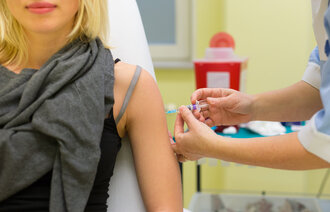 Bildet viser en kvinne som blir vaksinert