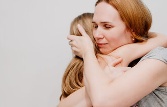 Bildet viser en mor som holder rundt sitt barn