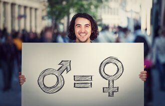 Bildet viser en man som holder opp en plakat som viser likhet mellom kjønnene