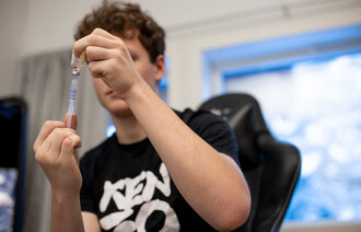 En gutt holder en insulinpenn