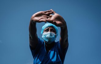 Bildet viser en sykepleier som holder hendene opp foran seg.
