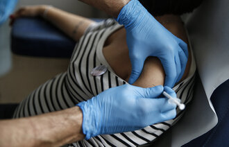 Bildet viser en gravid kvinne som skal til å få en koronavaksine.