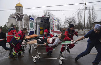 Ambulansepersonell flytter en skadet mann i et boligområde etter bombing i byen Mariupol i Ukraina.