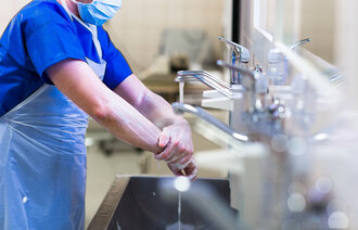 bildet viser helsearbeider som vasker hendene/armene