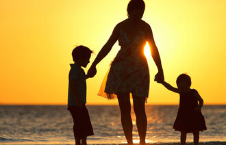 Familie i solnedgang på strand