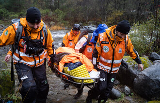 Bildet viser flere frivillige i Norsk Folkehjelp som har funnet den bortkomne etter leteaksjon