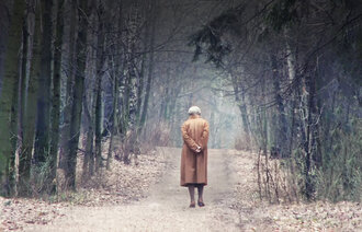Eldre person går i skogen