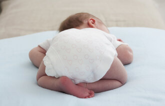 Bildet viser nyfødt baby som ligger på magen