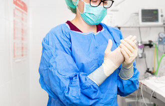 Bildet viser en sykepleier i fullt smittevernutstyr