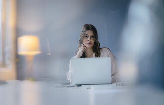 Bildet viser en ung kvinne som jobber på en datamaskin