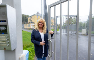 bildet viser Bente Sundbye ved den låste porten utenfor sikkerhetsavdelingen på Dikemark