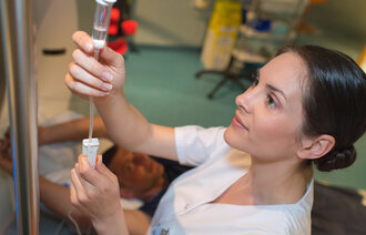Bildet viser en sykepleier som gir intravenøs medisin