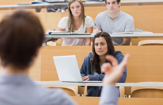 Bildet viser en gruppe studenter som lytter til en lærer