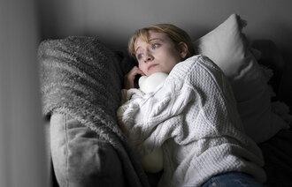Bildet  viser en kvinne som ligger i en seng.