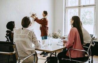 Bildet viser en gruppe kvinner som jobber sammen i et rom