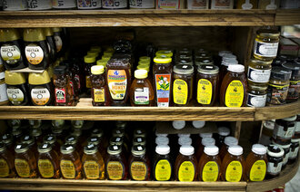 Bildet viser en butikkhylle full av honning