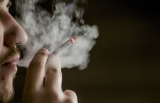 Bildet viser en mann som røyker en sigarett 