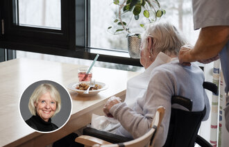 Bildet viser en sykepleier og en eldre kvinne ved matbordet på en helseinstitusjon.